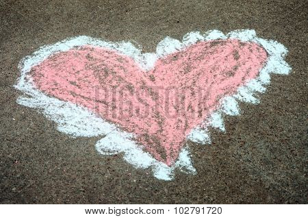 Child's sidewalk chalk drawing of pink and white heart