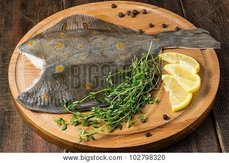 Fresh Raw Plaice With Pepper, Thyme And Lemon On The Board