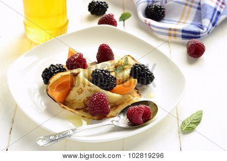?repes, fresh berries and honey on wooden background