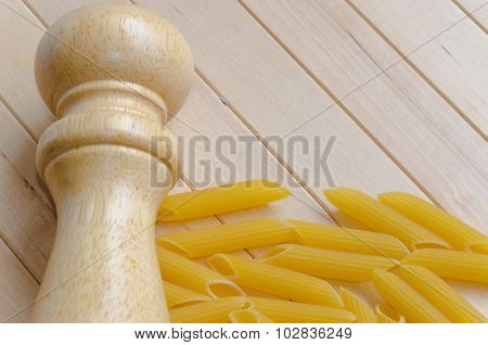 Pasta with salt caster on wooden background