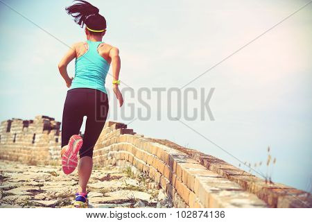 woman runner athlete running on trail at chinese great wall .