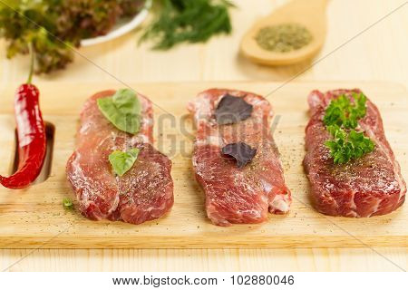 Fresh Raw Pork On Cutting Board With Spices And Herbs