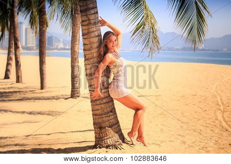 Blonde Girl In Lace Closeup Leans Back On Palm Smiles On Beach