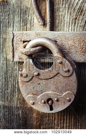 Old rusty padlock on wooden background