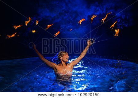 Fire dancer woman with fire in water