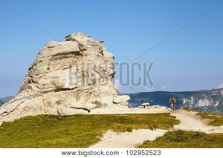 Unidentified biker climbs the hill in Bucegi Mountains in Romania
