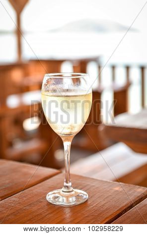 Glas Of Cold White Wine On A Wooden Table.