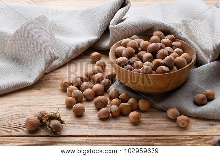 Hazelnuts in bowl on wooden table. All image in phocus