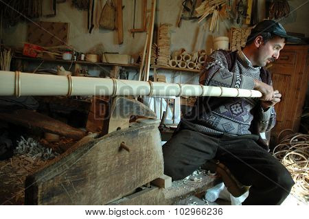 Carpenter Handcrafting A Wooden Alpenhorn