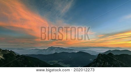 Mountain landscape panorama at sunset in Triglav National Park. Amazing view on colorful clouds and layered mountains in the evening. Colorful nature background. Adventure. Travel in Slovenia. Beautiful scenery.