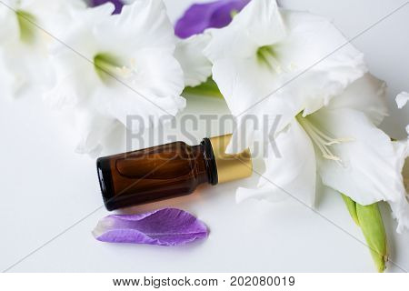 bottle of essential oil surrounded by flowers