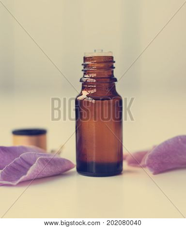 bottle of essential oil surrounded by flowers