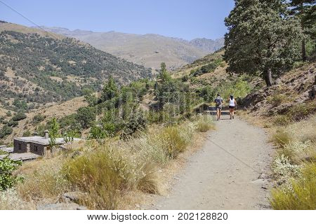 Hiking couple along Poqueira Gorge. Las Alpujarras Region Granada Spain