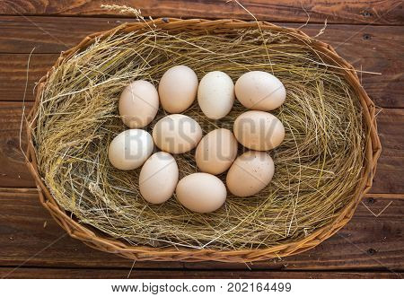 Chicken eggs in the wicker basket with hay. Eco concept