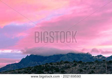 Pink sunset clouds over Chisos Mountain Range in Big Bend National Park Texas USA