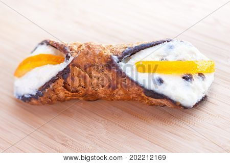Sicilian Cannoli traditional italian dessert with ricotta cheese and and chocolate bits isolated on wooden background close up