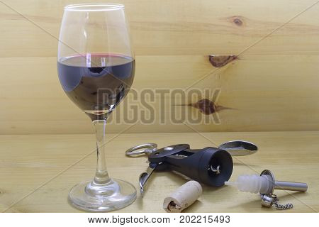 Glass of red wine and take out corks on natural wood background
