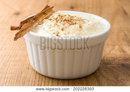 Arroz con leche. Rice pudding with cinnamon on wooden background
