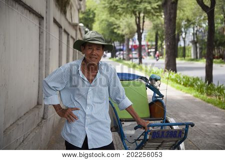 Ho Chi Minh City, Vietnam - March 27, 2017: Portrait of an old man with his  traditional cyclo
