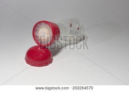 Glass Empty Pepper Mill With Red Top, Laying On Its Side