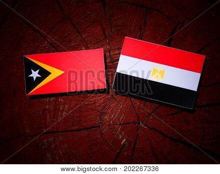 East Timorese Flag With Egyptian Flag On A Tree Stump Isolated