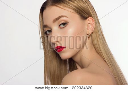 Person of model of fashion beauty. The magnificent beauty the blonde with a classical make-up. Red lips black shooters and white opaque skin. Long neck and pure leather. Cosmetology beauty shop