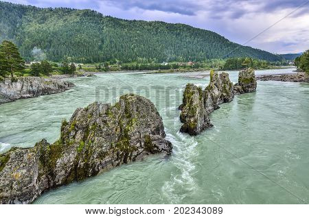 Picturesque summer landscape of fast mountain river with rocky islands in the form of pyramids as the ridge of a dragon Altai mountains Russia