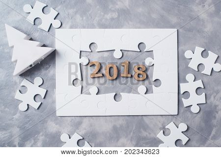 New Year Concept 2018. Jigsaw Puzzle On Grey Concrete Background.