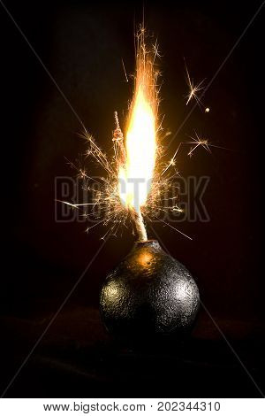 An old round bomb with a firing wick on a black background