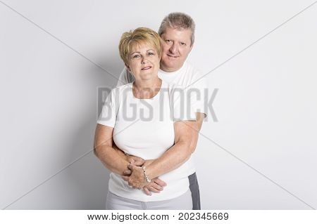 A Happy smiling senior couple standing together on white background