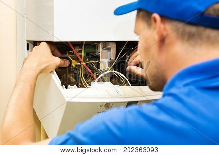 maintenance service engineer working with home gas heating boiler