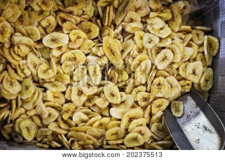 Sliced dried bananas with a metal shuffel spoon