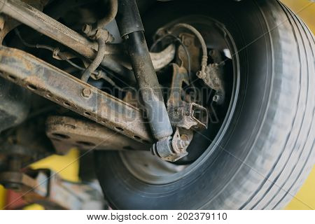 Car wheel bottom view. Garage mechanic raised the car on the lift. Object photo.