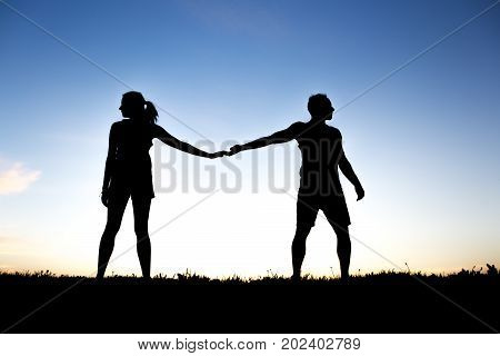 A silhouette of romantic lovers with sunset on the back