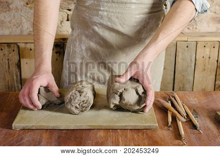 Potter Workshop Ceramics Art Concept - Standing Young Brunette Man Dressed In An Apron Male Hands Kn