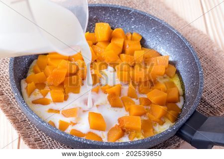 Preparation of pumpkin porridge. Pour the milk into pumpkin cubes