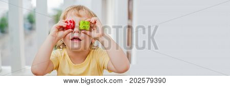 Banner The Boy Makes Eyes Of Colorful Children's Blocks. Cute Little Kid Boy With Glasses Playing Wi