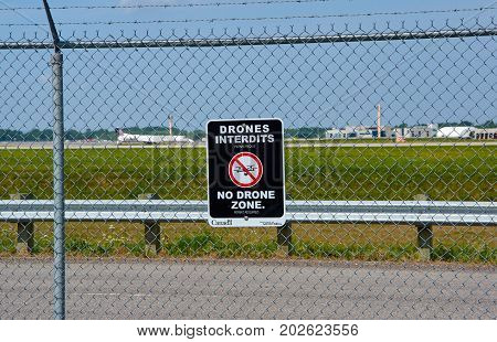 MONTREAL CANADA - AUGUST 28 2017 : No drones zone sign and airplane at Montreal YUL airport.