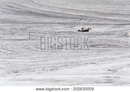 Snow Groomer Snowcat Stands On Dachstein Glacier Near Cable Car