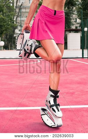 Fit Legs In Kangoo Jumping Shoes. Short Skirt, Beautiful And Sexy Girl Do Sport Kangoo Exercises On