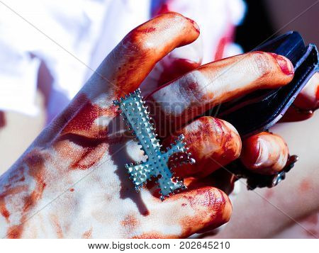 Christian religion symbol cross hands young woman bleeding zombiewalk fake blood