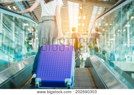 Asian women were carrying luggage around the international airport. She was traveling abroad to travel on weekends.