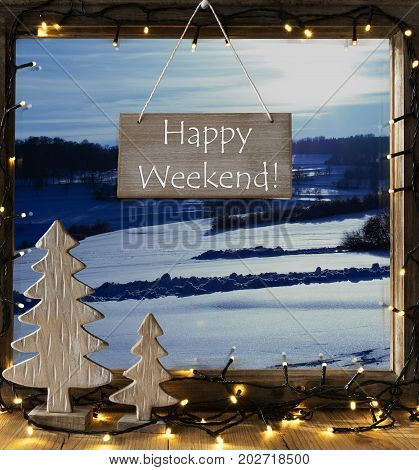 Sign With English Text Happy Weekend. Window Frame With Winter Landscape With Snow. View To Snowy Scenery Outside. Christmas Tree And Fairy Lights.