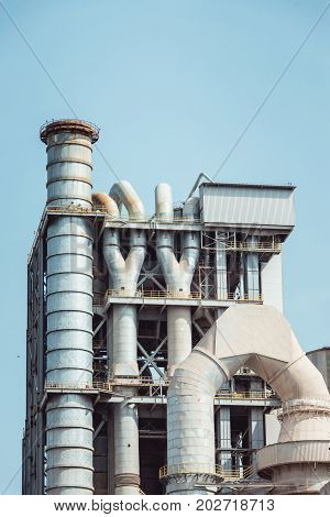 Cement factory machinery on a clear blue sky.