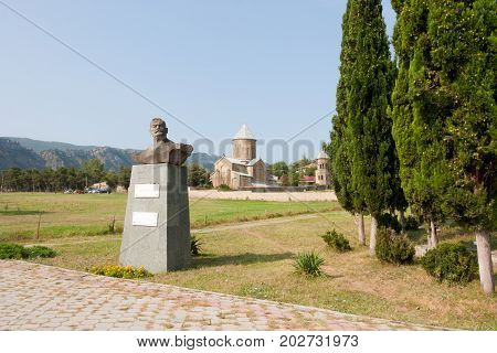 Mtskheta, Georgia- AUGUST 17, 2013: Samtavro Transfiguration Orthodox Church and Nunnery of St. Nino in Mtskheta.The monument to the famous Georgian wrestler, circus performer and movie Sandro Kandelaki. Georgia