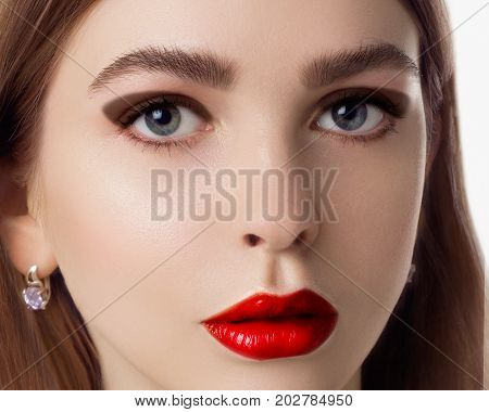 The beautiful femme fatale with a bright make-up and a captivating look. Fashionable make-up close up. Fashion photo