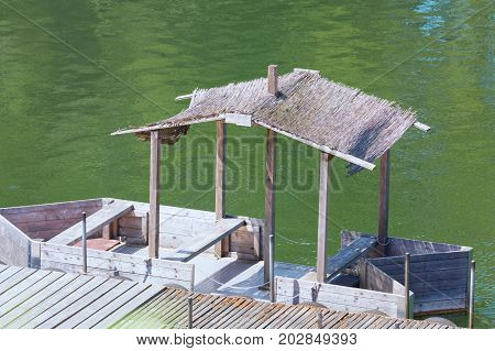 Bootssteg mit einfachen Bootshaus oder Holzboot mit Strohdach.