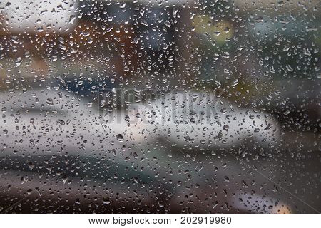 Background of moving rain drops on a window glass in a rainy day. Auto
