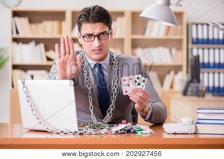 Young businessman addicted to online gambling cards playing in t