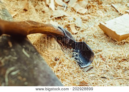 Rusty tip of sharp ax lies on edging boards